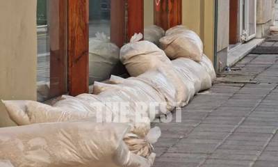Μαγαζάτορες στην Πάτρα βάζουν τσουβάλια με άμμο για να «οχυρωθούν» από την κακοκαιρία (photos)